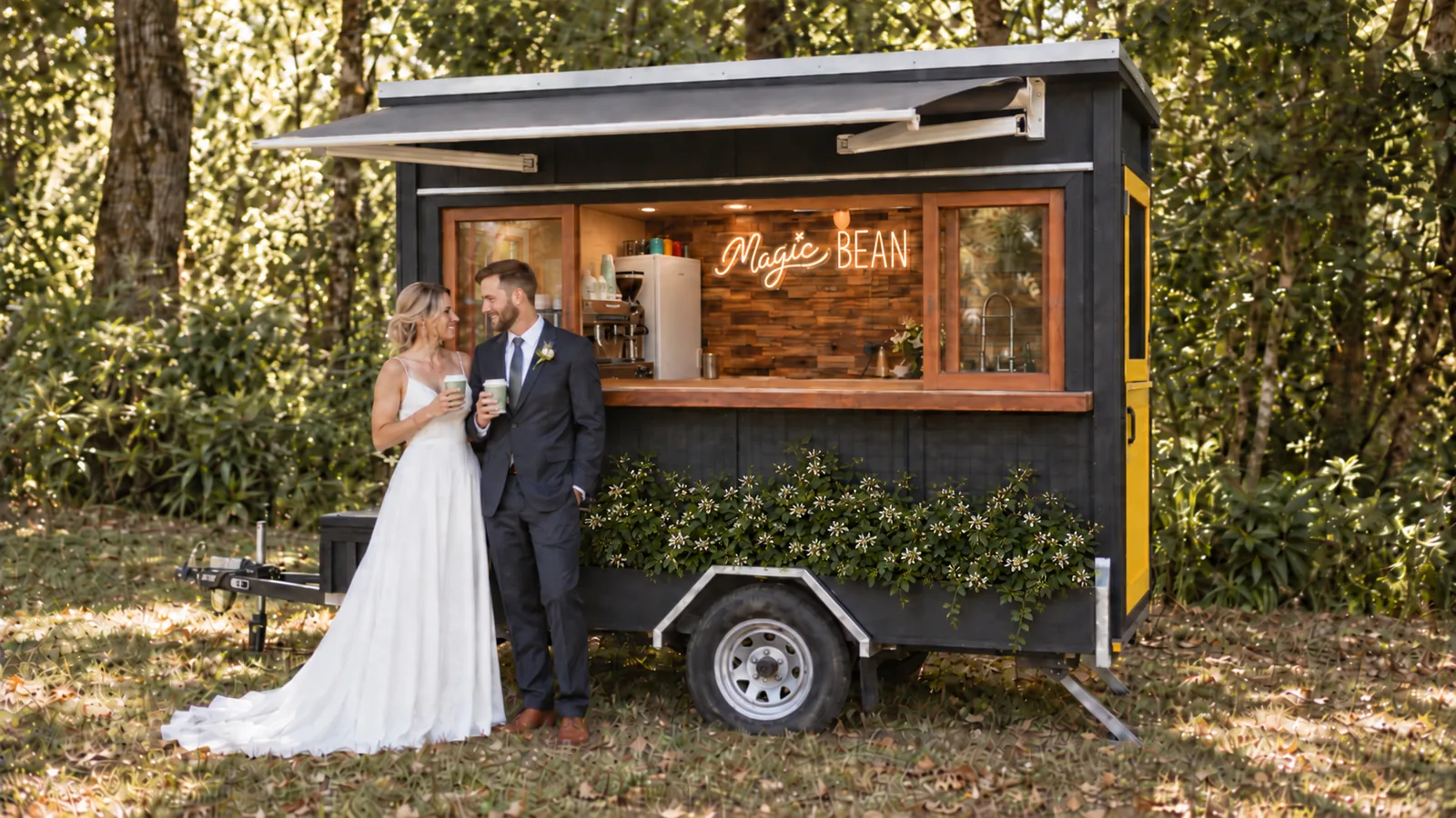 Full side view of the bespoke black Magic Bean coffee cart with timber windows and star jasmine growing across the front